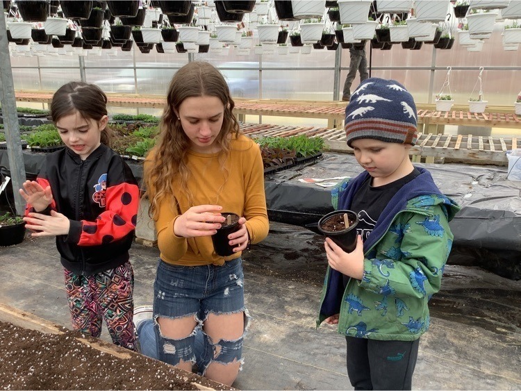 High school FFA member gardening with elementary students