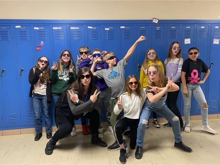 a teacher and students in fun outlandish poses wearing sunglasses